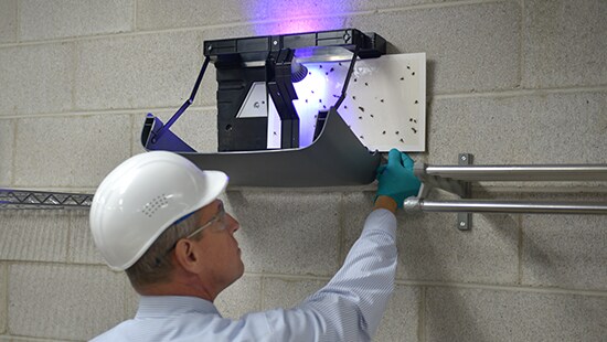 Ecolab LED Fly Light being serviced by an Ecolab Pest Elimination Service Specialist