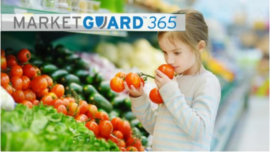 Small girl in a supermarket holding tomatoes in her hands